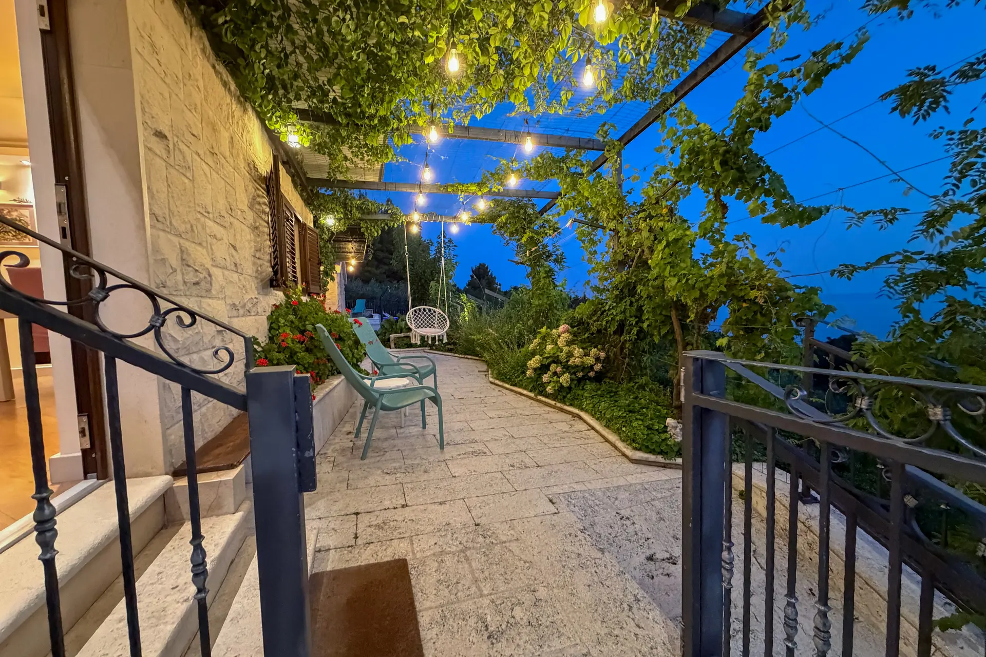 Lit courtyard and pergola at Villa Dalmatia in the evening