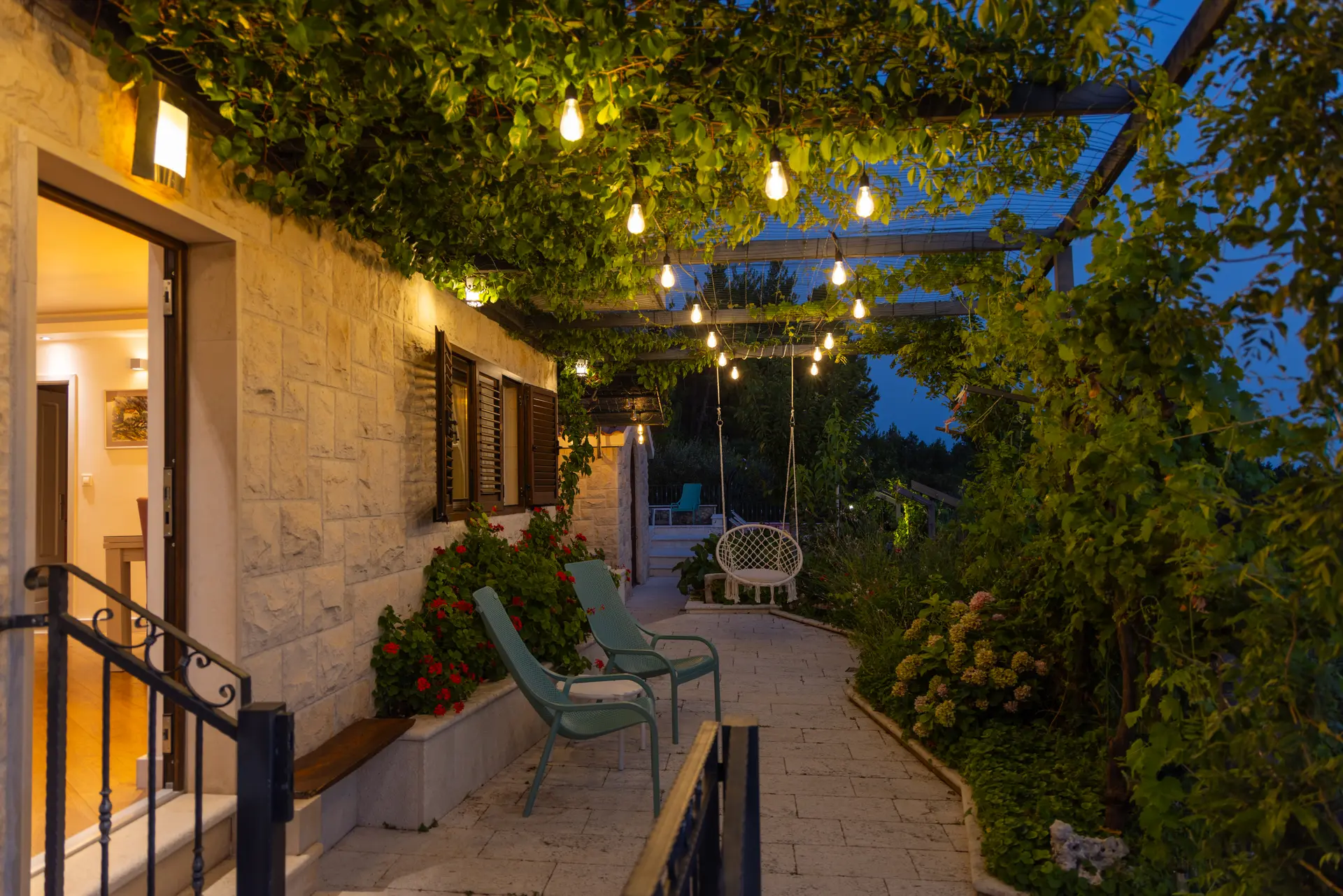 Illuminated vine-covered terrace at Villa Dalmatia after sunset